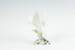 A Lladro fantail dove alighting on a blossom branch