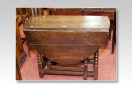 An 18th Century oak dropleaf oval gateleg tea table with bobbin and block supports