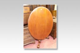 A Victorian mahogany oval tilt top loo tea table with centre segmented pedestal and a circular
