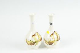 A pair of Moorcroft cream ground narrow necked vases, `Leaves in the Wind` pattern, 8 ins (21 cms)