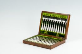 A mahogany cased set of twelve bone handled fish knives and forks, all with bright cut blades