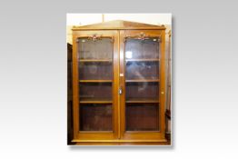A Victorian mahogany top of a two door glazed bookcase; and a mahogany and walnut bow front mirror