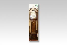 An early 19th Century mahogany long case clock having an arched hood with brass scrolled pediment