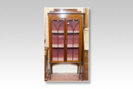 An Edwardian mahogany and inlaid two door standing china cabinet having a shaped rail back with a
