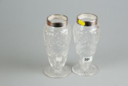 A pair of circular based cut glass vases with tapered bodies and having silver necks, 7.75 ins (19