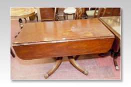 A 19th Century mahogany breakfast table with narrow drop leaves and having a centre turned
