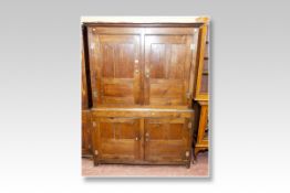 An 18th Century oak two piece press cupboard, the upper section having twin doors with brass H