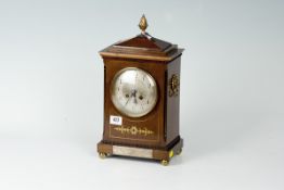 An early 20th Century rosewood and brass inlaid mantel clock having a stepped and raised top with