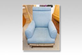 A blue upholstered polished framed rocking chair