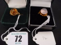 A nine carat gold oval amber dress ring in a rope twist mount; and a believed gold dress ring with