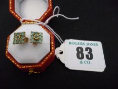 A pair of nine carat gold emerald earrings, square set, each with nine tiny stones and butterfly
