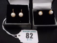 A pair of nine carat gold and pearl hoop style earrings; and a pair of small pearl earrings with