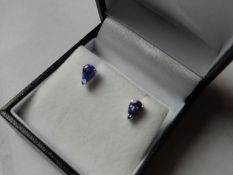 A pair of silver and pear shaped blue stone earrings.