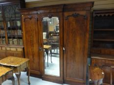 A turn of the Century mahogany linen press and wardrobe having a centre mirrored door, 72 ins