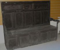 A late 17th / early 18th century carved Welsh box-seat settle having eight Celtic carved panels to