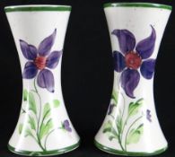 Llanelli Pottery; a pair of early 20th Century waisted circular based vases, hand painted with