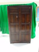A Priory (or style) darkwood linenfold two door corner hall robe.