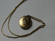 An oval yellow metal locket on a nine carat gold link chain, 5 grms gross and a nine carat gold back