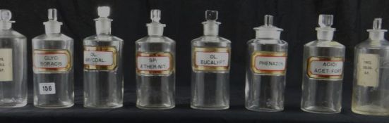 Eight clear glass pharmaceutical jars with labels, approximately 7.75 ins high.