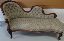 A mahogany framed scroll back early Victorian chaise longue on cabriole legs and castors with