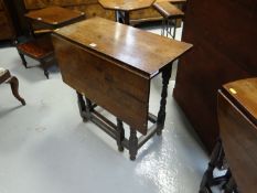 An 18th Century oak single flap gate leg table on turned and block supports with plain stretchers,