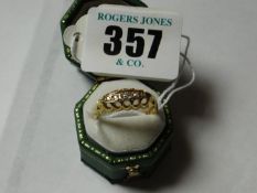 An eighteen carat gold dress ring with five tiny diamonds.