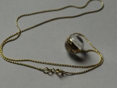 A nine carat gold banded crystal ball pendant with a nine carat gold dart link chain, total 6 grms.