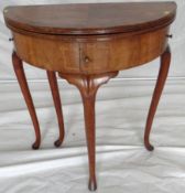 An 18th Century partially restored walnut half round foldover games table with green baize lined