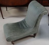 A small blue velvet upholstered Edwardian slipper chair on turned front supports and castors and a