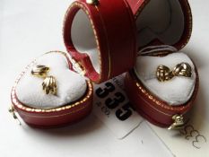 A pair of nine carat gold fan shaped earrings and a pair of nine carat gold triple looped earrings.