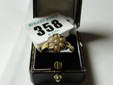 A nine carat gold floral cluster ring of seven small pearls, 7 grms gross.
