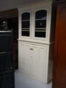 A painted pine Welsh ‘Cwpwrdd Gwydr’ (glazed cupboard) with two glazed doors above a two door