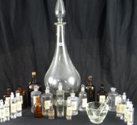 A large circular based clear glass apothecary bottle, 33 ins high (with stopper); a glass pestle and