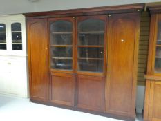 A large mahogany bookcase cupboard having two centre cupboard doors below two arched shaped glazed
