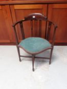 An Edwardian inlaid mahogany corner chair with shaped, padded and upholstered seat.