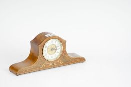 A small mahogany and inlaid Edwardian mantel clock, the shaped case enclosing a circular brass