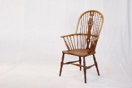 An elm Windsor wheel and spindle back elbow chair with turned front supports.
