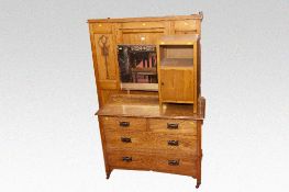 A compact late Edwardian oak wardrobe; and similar dressing table of two long and two short drawers.