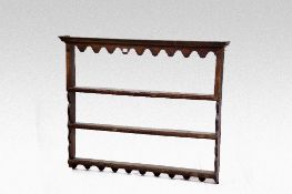 A three shelf open backed oak Delft rack with shaped apron and shaped side uprights, 52 ins (132
