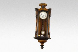A walnut and ebonised encased compact Vienna style pendulum wall clock with circular white dial