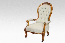 A late Victorian walnut buttoned and upholstered spoonback armchair on carved and knurled supports.