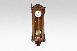 A rosewood encased Vienna style single weight pendulum wall clock having a circular dial with