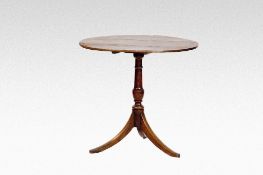 A circular antique oak tripod table with turned centre pedestal and three splayed supports.