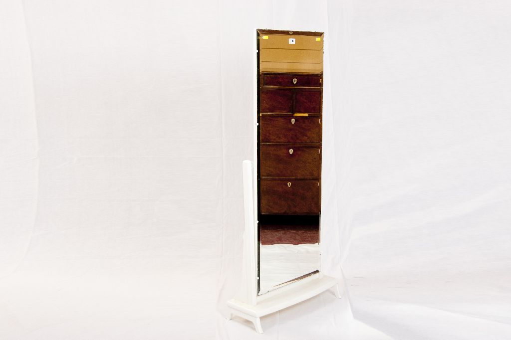 An unframed cheval mirror with bevelled glass and painted uprights and base.