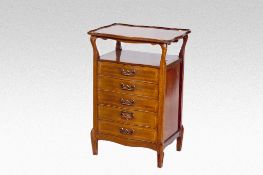 An early 20th Century mahogany music cabinet having a shaped shelf top over a shelf recess and