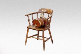 A polished spindle backed desk chair; and a brass banded brandy cask.