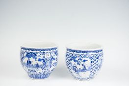 A pair of 18th Century blue and white Oriental jardinieres having floral decoration and panels of
