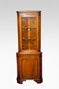A reproduction lightwood glazed top corner display cabinet.