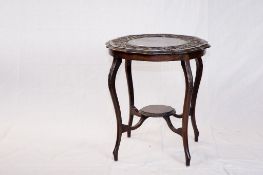 A late Edwardian circular top mahogany occasional table with a carved border and a small base