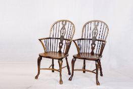 A pair of elm and polished Windsor splat and spindle backed elbow chairs having crinoline stretchers